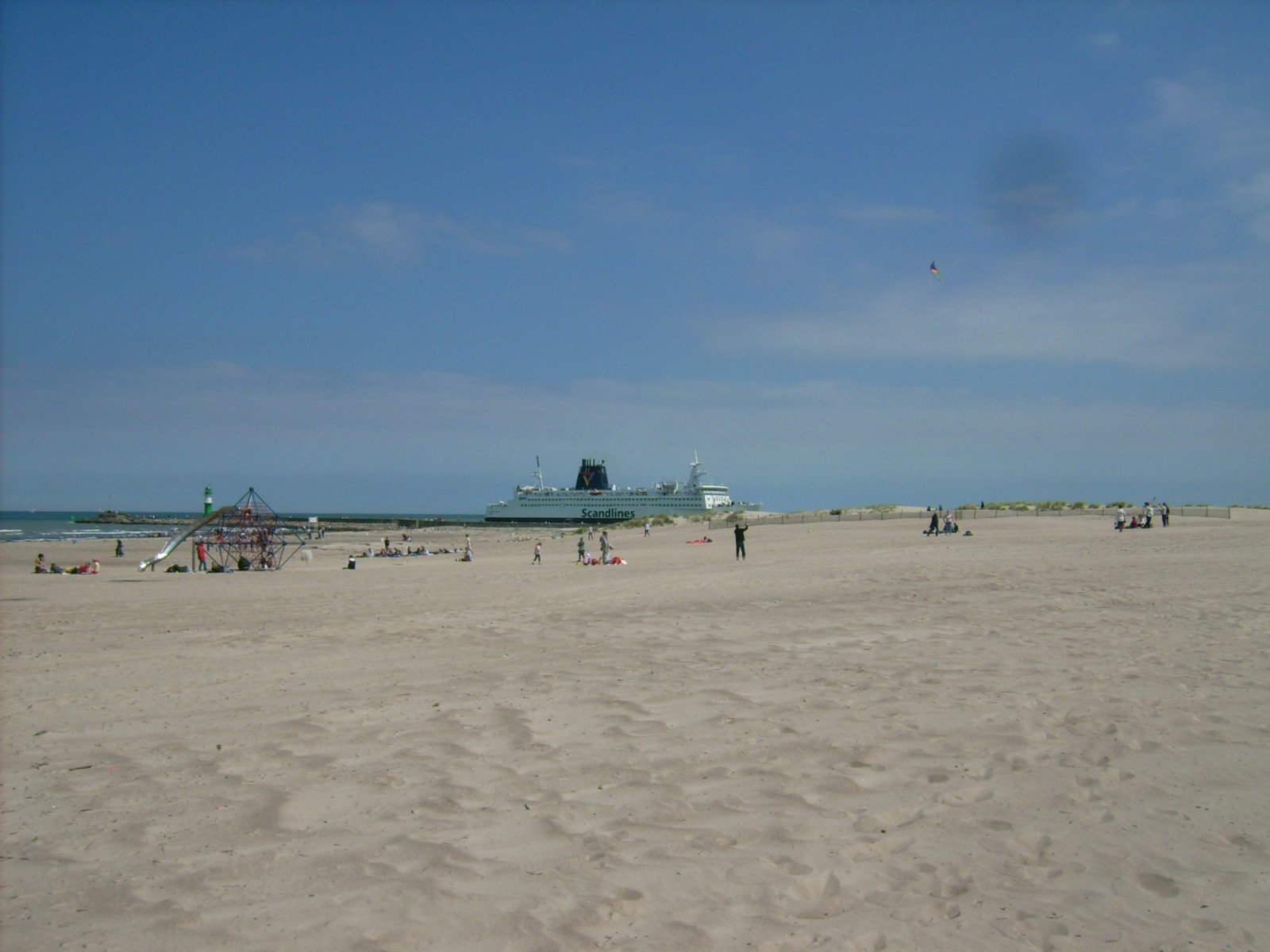 Farbphoto: Blick auf Sandstrand, Mole und auf eine in den Hafen einlaufende Scandlines-Fähre. Warnemünde Juni 2009. Photograph: Bernd Paepcke.