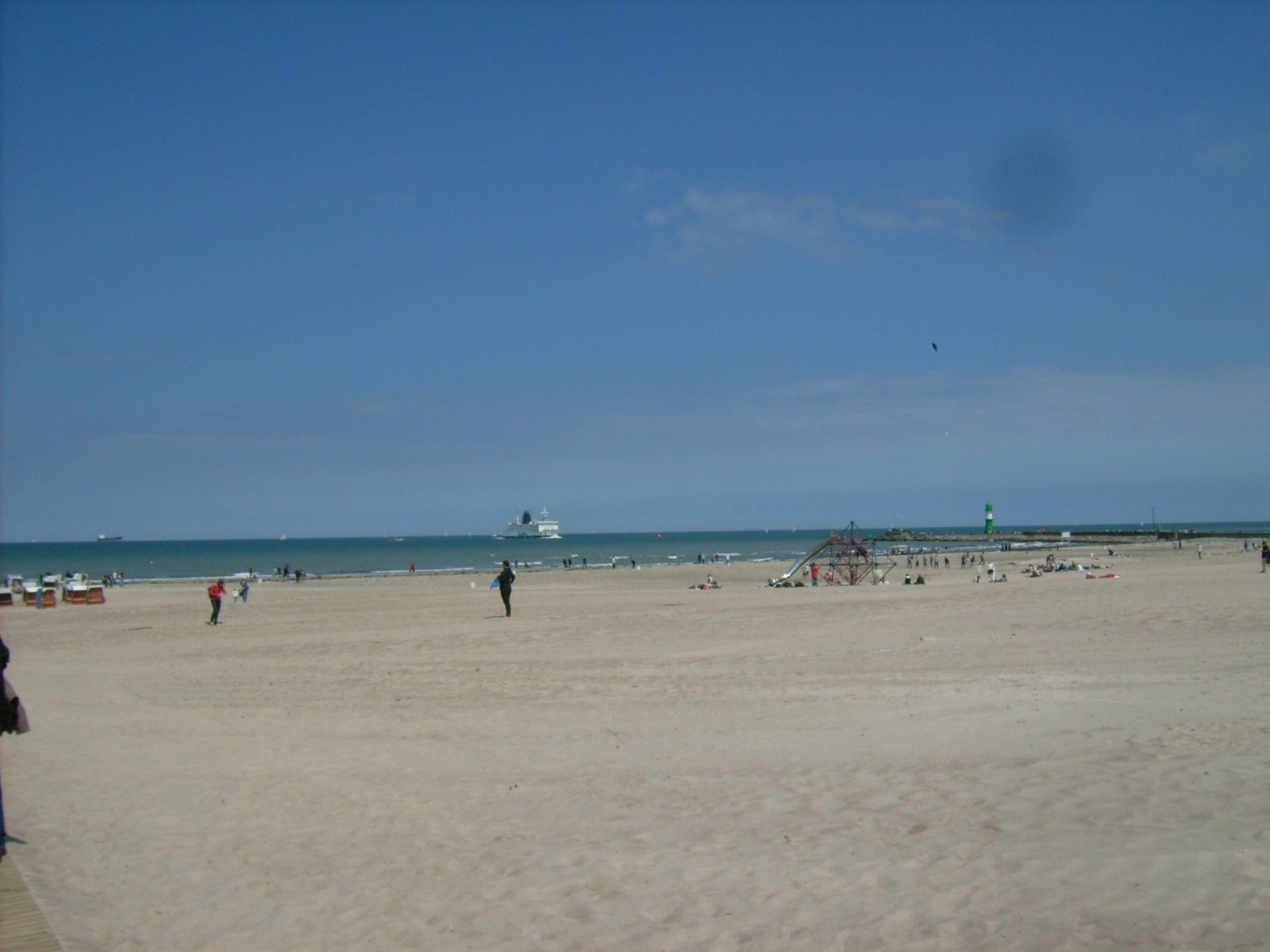 Farbphoto: Blick auf den Sandstrand von Warnemünde und auf die Ostsee. Auf der Ostsee eine den Hafen von Warnemünde/Rostock anlaufende Skandinavienfähre. Juni 2009. Photograph: Bernd Paepcke.