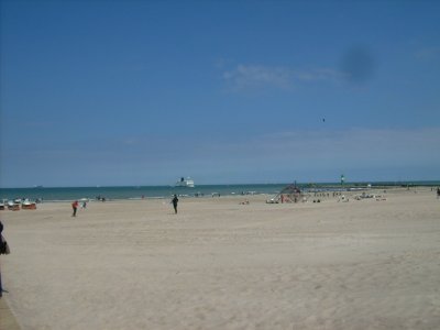 Farbphoto: Blick auf den Sandstrand in Warnemünde und auf eine  aus der Ostsee in den Hafen von Rostock hereinfahrende Skandinavienfähre. Juni 2009. Photograph: Bernd Paepcke.