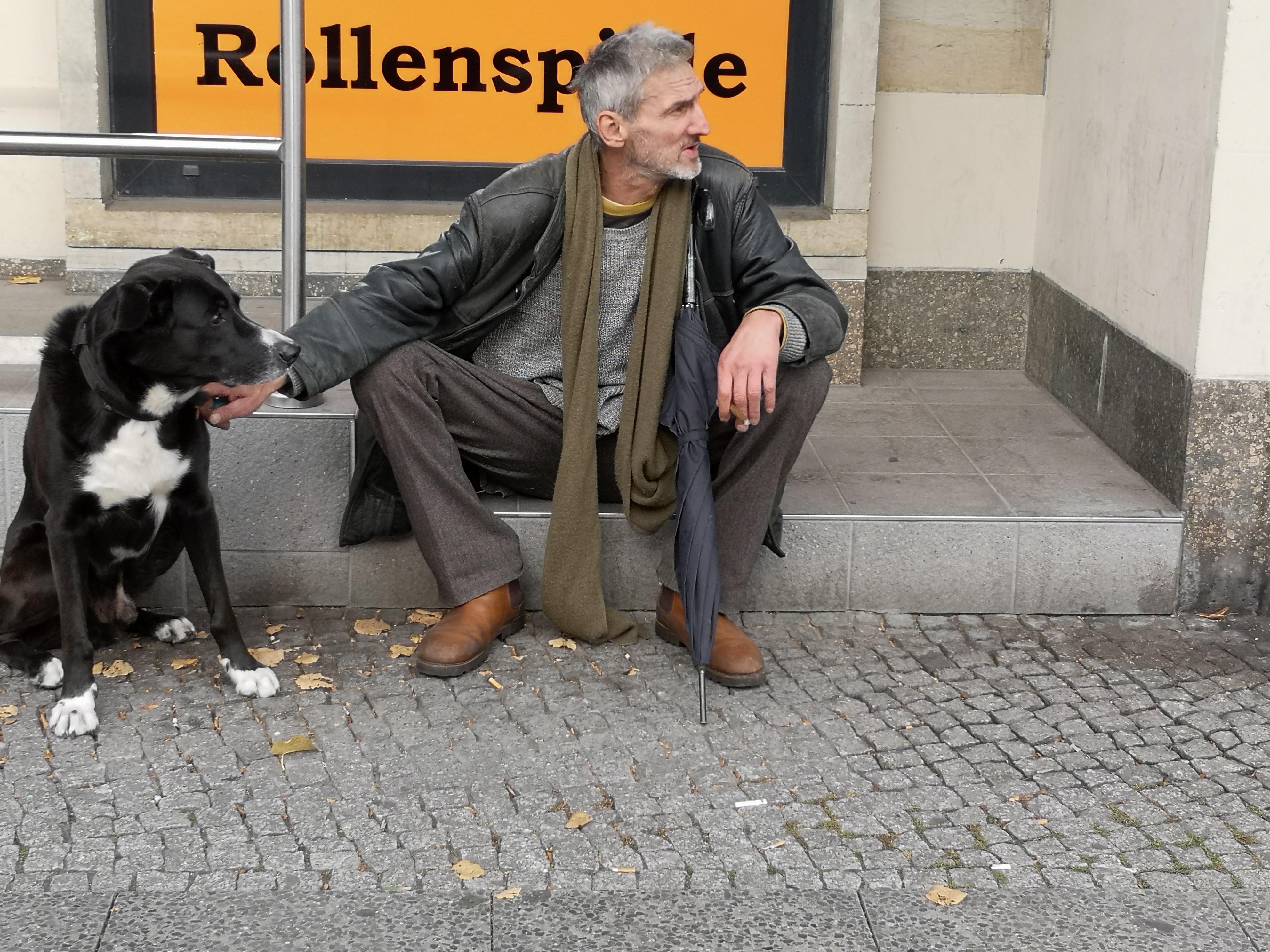 Farbfoto von einem Hund und seinem Mensch in der Frankfurter Allee in Friedrichshain. Im Oktober 2024. Fotograf: Erwin Thomasius.