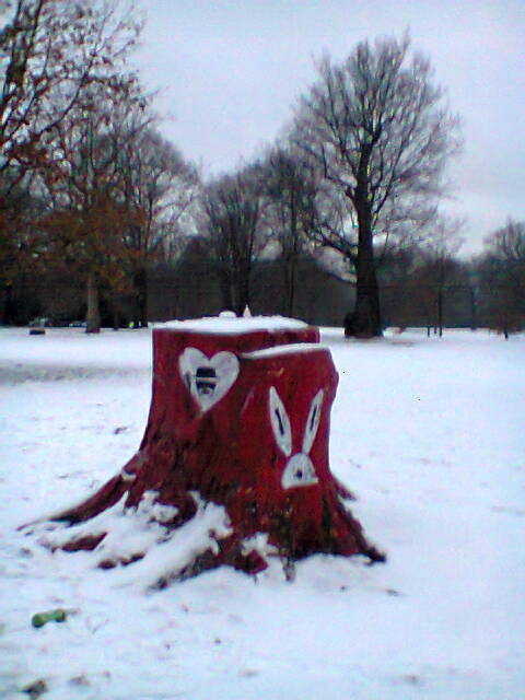 Farbfoto: Ein bunt angemalter Baumstumpf im Schnee in der Hasenheide. Im Februar des Jahres 2013. Copyright by jen.