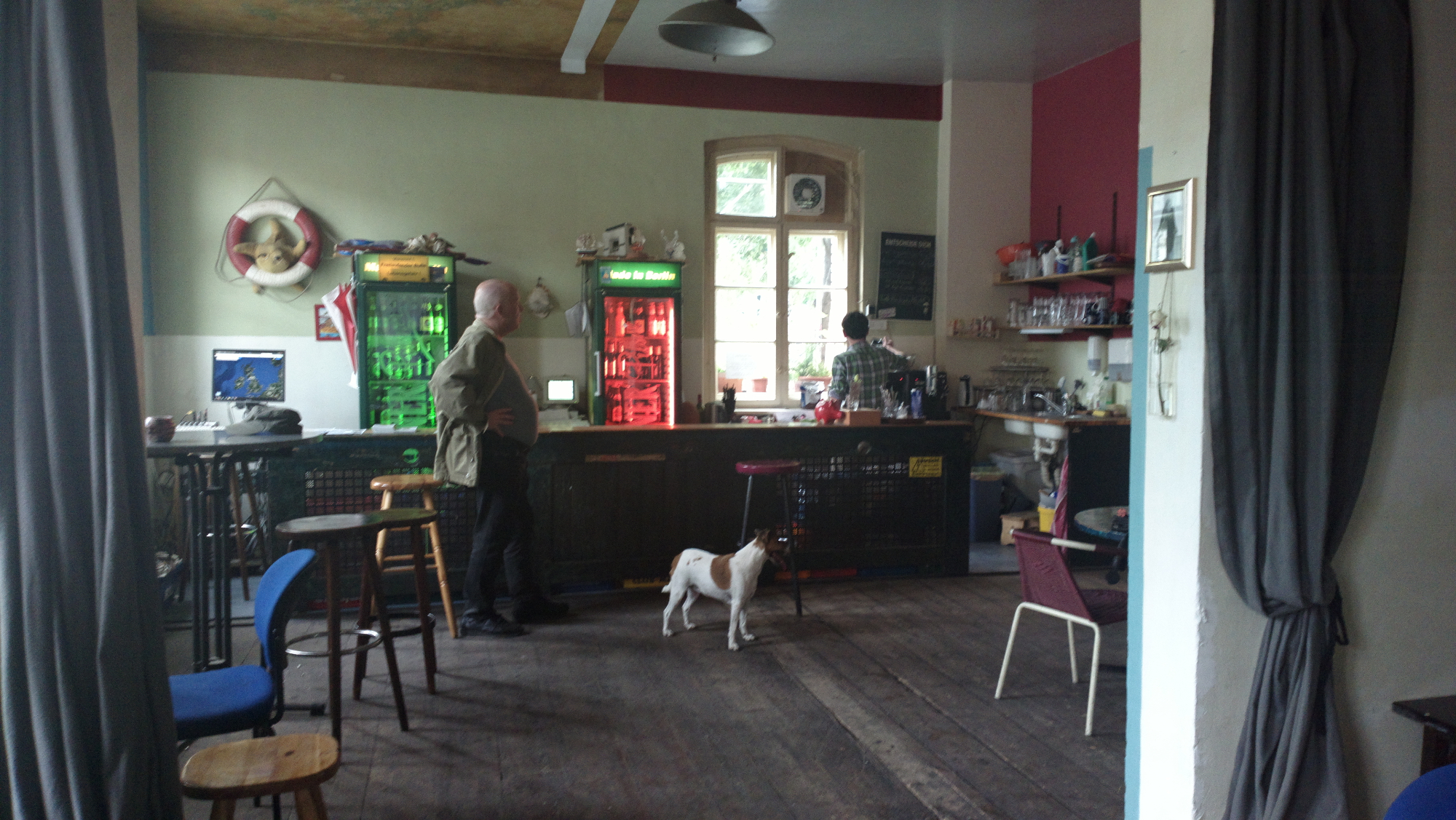 Farbfoto: Von links nach rechts: Die Huendin Speedy und der Mensch Erwin Thomasius in der Teestube die Kueste in dem Friedrichshainer Kulturzentrum RAW-Tempel im Juni des Jahres 2014. Fotograf: Kim Hartley.